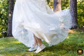 Bride standing in the backyard of a home in Atlanta, Georgia, with her tennis shoes playfully visible beneath her wedding dress.